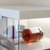 Elegant whiskey bottles in a contemporary glass cabinet under soft lighting.